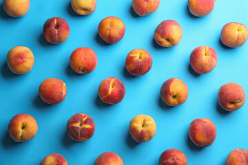 Fresh ripe peaches on light blue background, flat lay