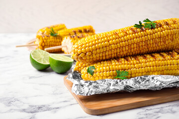 Tasty grilled corn on white marble table