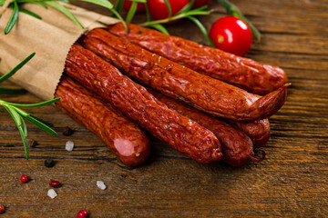 Kabanos or Cabanossi Thin Dry Smoked Polish Sausage on Wooden Background. Selective focus.