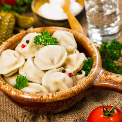 Beef and Pork Dumplings - Russian and Ukrainian Meat Pelmeni on Wooden Background. Selective focus.