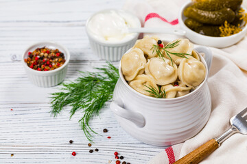 Beef and Pork Dumplings - Russian and Ukrainian Meat Pelmeni on Wooden Background. Selective focus.