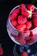 Fresh red raspberries on a dark wood background. Place for text