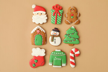 Different Christmas gingerbread cookies on brown background, flat lay