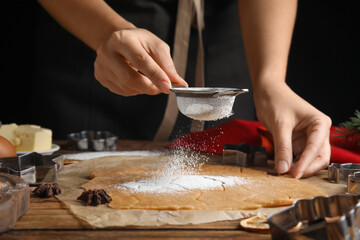 Woman making Christmas cookies at wooden table, closeup