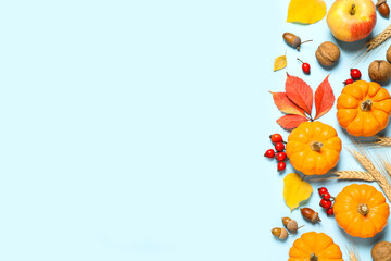 Flat lay composition with ripe pumpkins and autumn leaves on light blue background, space for text. Happy Thanksgiving day
