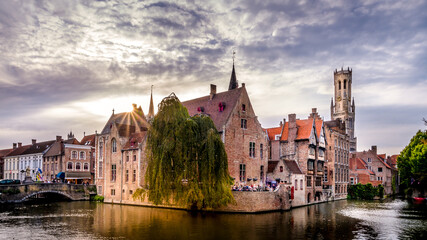 Fototapeta na wymiar Sunset over the Historic buildings and the Belfort Tower viewed from the Dijver Canal in the medieval city of Bruges, Belgium