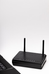 black wifi router and laptop over white background. online and network conceptual. copy space. studio shot