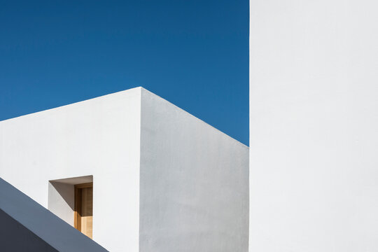 Fototapeta Generic geometric minimalist white architecture on a clear sunny day.