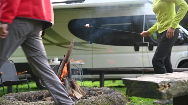 Couple Cooking Sausage on Camping Campfire