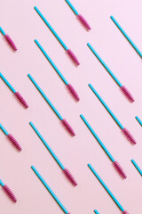 Eyelash brushes on a pink background, pattern.