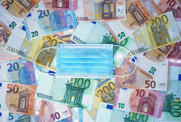FACE MASK ON BACKGROUND OF EURO BANKNOTES. WORLD FINANCIAL CRISIS DUE TO
CORONAVIRUS PANDEMIC. TOP VIEW.