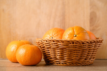 Fresh Honey Murcott orange fruit in basket on wooden background