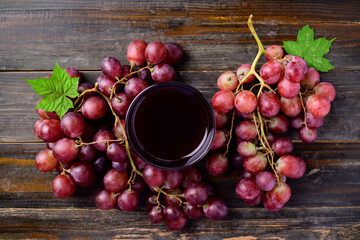 Fresh red grapes fruit and juice on wooden background, Top view