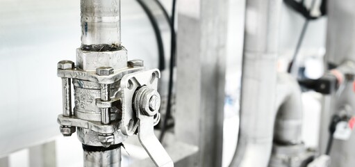 Large industrial water treatment and boiler room. Shiny steel metal pipes and switches