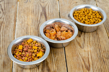 Metal bowls with different pet foods. Photo