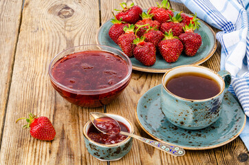 Ripe red sweet strawberry jam, fresh berries on wooden table