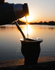 Sunset drinking mate in a lake
