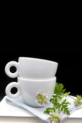 Pile of books and coffee cups on black background