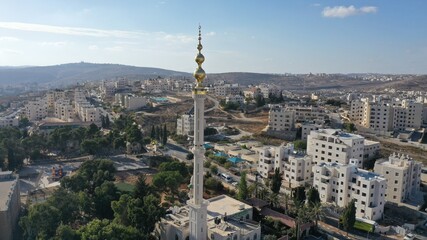 Fototapeta na wymiar Golden Mosque Tower Minaret in Beit Hanina, Aerial view Palestinian Muslim Mosque Masjed aldaoa, Drone image 