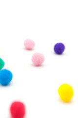Colorful pompoms on white background.