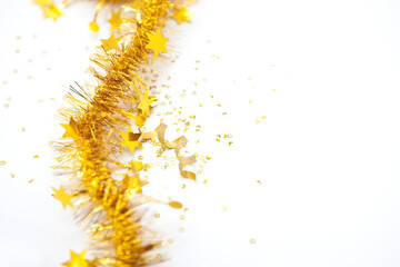 Close up of gold tinsel and curly ribbon on white background.