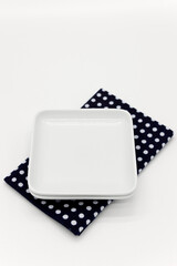 White plate on blue dot kitchen cloth.