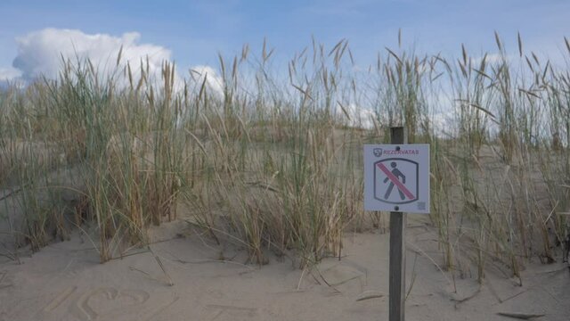 Forbidden to walk sign on sandy dunes in Lithuania, Neringa. Restricted area, danger to walk for pedestrians. 