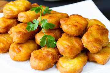 Asian style battered and deep fried chicken nugget in sauce