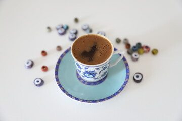 Blue Turkish coffee cup and beads on the white background
