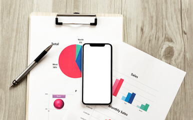 Business documents and a smartphone on the table or desk....
