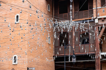 Lots of garland bulbs hanging in front of a building's outdoor area for decoration.

