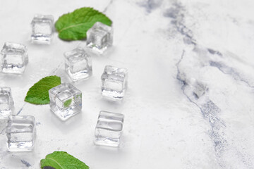 Ice cubes and mint leaves on light background