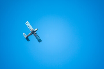 Retro green biplane plane in the blue sky