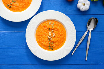 Tasty pumpkin cream soup in bowls on table