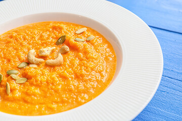 Tasty pumpkin cream soup in bowl on table, closeup