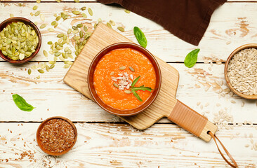 Tasty pumpkin cream soup in bowl on table