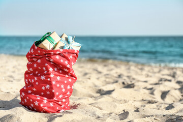 Santa Claus bag with gifts on beach