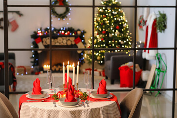 Interior of room with table set for Christmas dinner