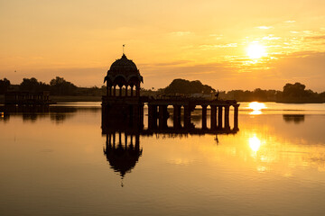 Obraz premium sunrise view of Ancient architecture ruins at Gadi Sagar (Gadisar) lake Jaisalmer, Rajasthan 