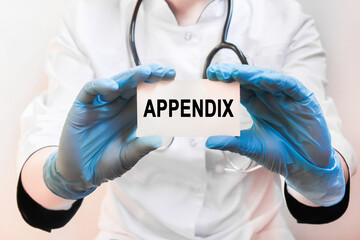 The doctor's blue - gloved hands show the word APPENDIX - . a gloved hand on a white background. Medical concept. the medicine