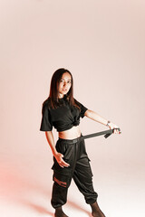 girl of Asian appearance on a pink background, holding a waist belt in her hands