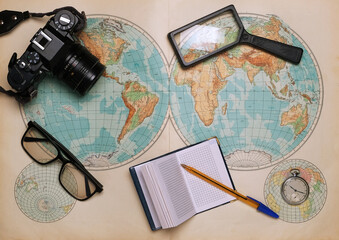 old map of the hemispheres on it a camera, clock, magnifier and a notebook