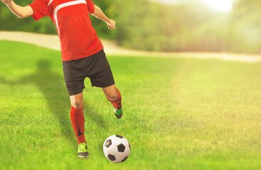 Running soccer player on stadium grass