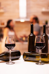 Celebrating relationship with red wine in kitchen.