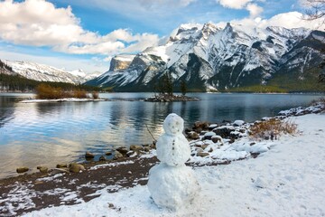 Snowman at shore of Lake Minnewanka after early snowfall in Banff National Park, Canadian Rocky...