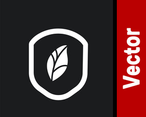 White Shield with leaf icon isolated on black background. Eco-friendly security shield with leaf. Vector Illustration.