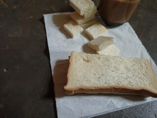 A cup of milk coffee, white bread slices, isolated against the background of the floor.