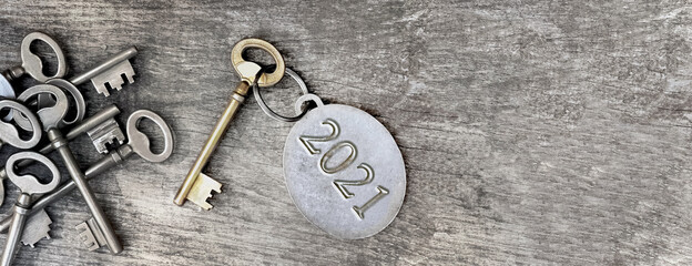 2021 engraved on a ring of an old key on wooden background