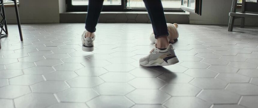 CU on legs, female cleaning up toys from the floor in the house. Shot on RED cinema camera with 2x Anamorphic lens