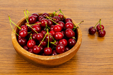 Wooden bowl with ripe sweet garden cherry